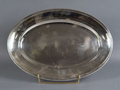 a silver plate on a stand on a grey background