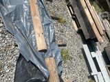 a pile of wood sitting on the ground next to a pile of other wood