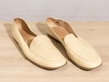 a pair of beige shoes sitting on top of a wooden table