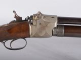 un gros plan d'un pistolet sur une surface blanche avec un fond blanc