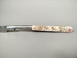 a knife that has been decorated with flowers on it