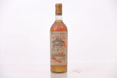 une vieille bouteille d'alcool posée sur une table blanche