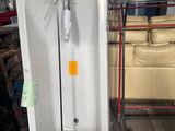 une baignoire blanche posée sur une palette dans un entrepôt