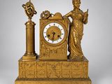 une horloge en or surmontée d'une statue