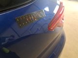 a close up of a blue car with a sticker on it