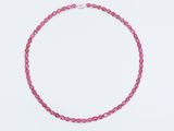 un collier de perles roses sur fond blanc