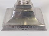a silver object on a white surface with a black and white background