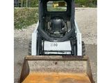 a picture of a small ski - door parked in a gravel lot