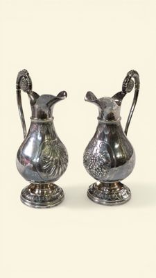 deux vases en argent posés l'un à côté de l'autre sur une table