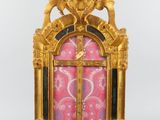 an image of a gold clock with a pink background and gold decorations
