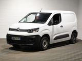 la camionnette blanche est garée dans une grande pièce au sol en damier