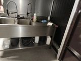 un évier en inox et un réfrigérateur en inox dans une cuisine
