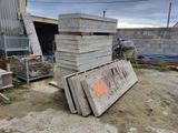 a pile of wood sitting on the ground next to a building