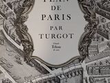 une vieille carte de Paris avec, au centre, une illustration représentant une ville