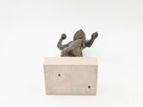 a small statue of a man laying on a block