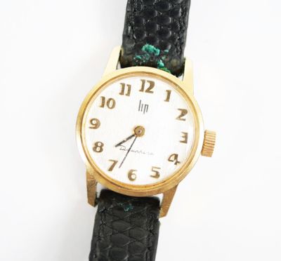une montre-bracelet en or avec un bracelet en cuir noir