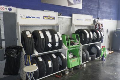 beaucoup de pneus empilés sur un support dans un garage