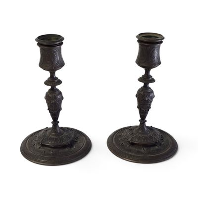 paire de bougeoirs anciens en bronze, dont les socles sont ornés de motifs élaborés