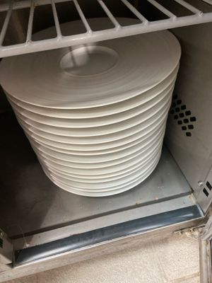 a stack of plates sitting in a dishwasher in a kitchen