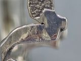 silver ring with a dog on it ' s head and a bird on its back