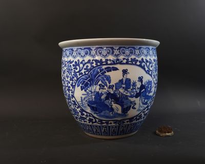 a blue and white vase sitting on a table with a penny