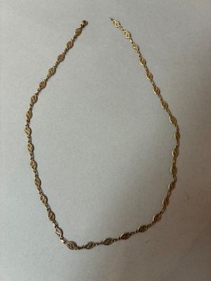 un collier en or représentant une corde torsadée sur fond blanc