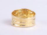 a close up of a gold ring on a white surface