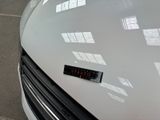 a close up of a white car with a sticker on it