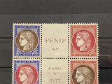 quatre timbres différents exposés dans une vitrine, sur lesquels figurent plusieurs têtes