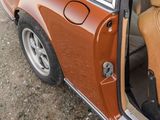 a brown car with its door open on the side of the road