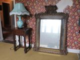 a mirror and a lamp in a room with a wallpapered wall
