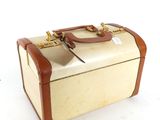 a small suitcase sitting on a white surface with a tag on it