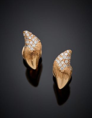 une paire de boucles d'oreilles en or serties de diamants sur fond noir