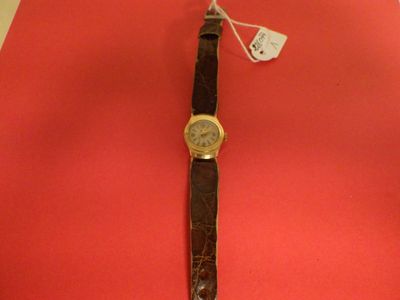 wrist watch on a red surface with a price tag attached to it