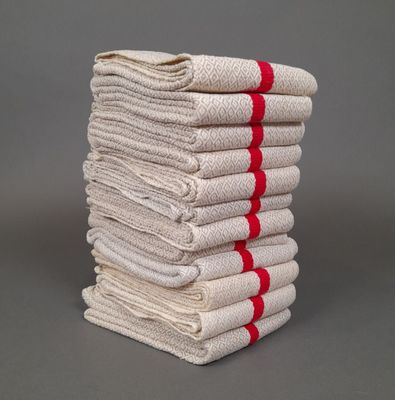 une pile de serviettes blanches et rouges posée sur une surface grise