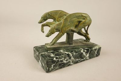statue représentant deux lévriers en pleine course, posée sur un socle en marbre