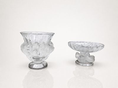 two glass vases sitting next to each other on a white surface