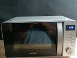 Quelqu'un prend une photo d'un micro-ondes posé sur une table en bois.