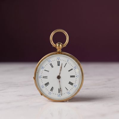 une montre de poche en or avec des chiffres romains sur le cadran