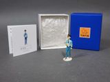 a small figurine of a man in a blue shirt and jeans