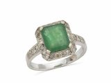 gros plan d'une bague avec une pierre verte entourée de diamants