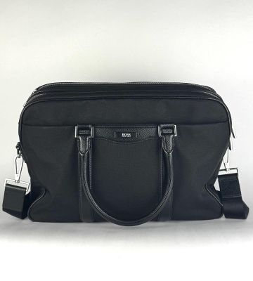 un sac noir muni d'une poignée noire et d'une bandoulière noire