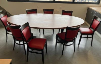 a round table with six red chairs around it