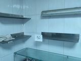 a glass shelf in a bathroom with towels on it