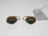 a pair of gold and jade earrings