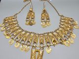 a gold necklace and earring set on a table