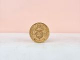a gold coin sitting on top of a white surface
