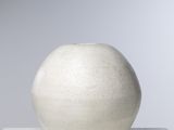 un vase blanc posé sur une table blanche