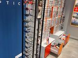 many glasses on display in a store with a blue wall