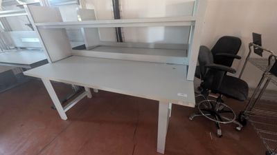 un bureau blanc avec une chaise noire dans une pièce